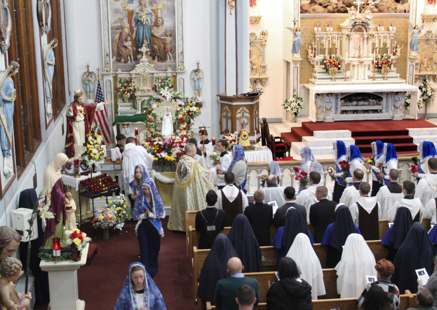 Sodalists bring flowers to present to Our Lady.