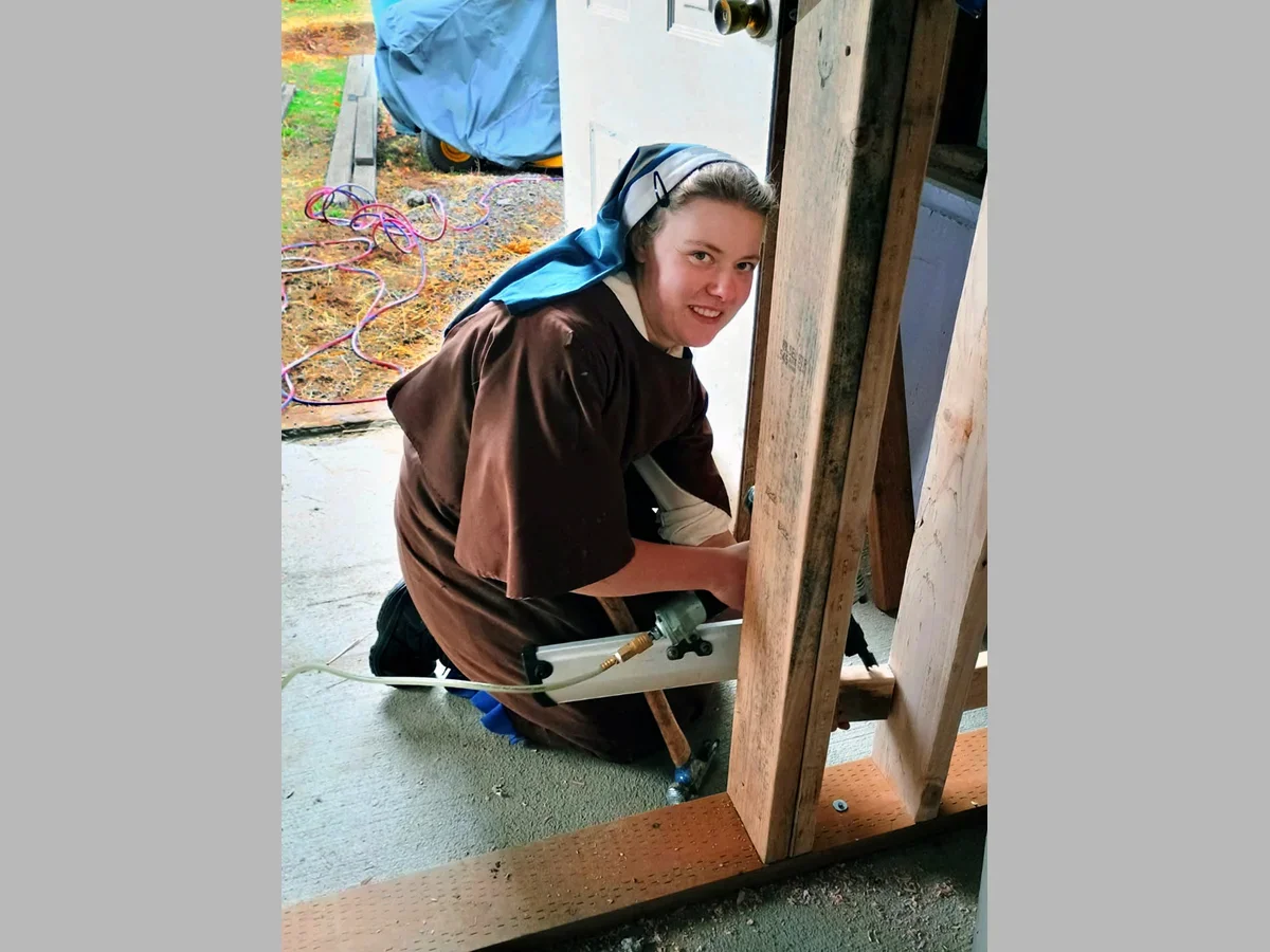 Sr. Virginia gets some construction experience as a section of the barn is closed in for a storage area.