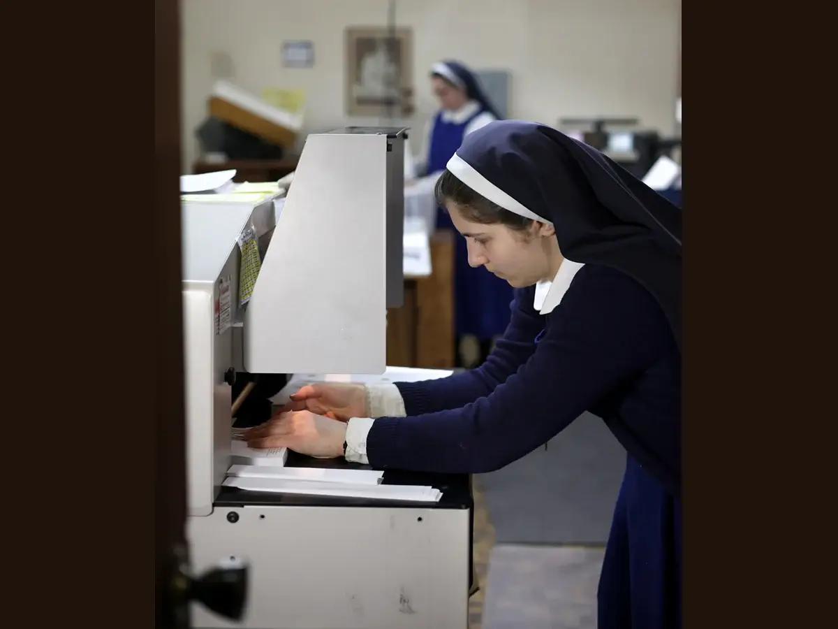 Sr. Maria looks very focused as she sets up a job on the electric cutter.
