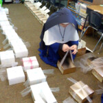 For parishioners unable to attend Holy Week liturgies at St. Mary’s in Tacoma, the Sisters prepared sacramental boxes containing blessed palms, holy cards of the
Passion, a white chocolate chalice, and powerful Easter water Preparing sacramental boxes for parishioners confined to home by the COVID-19 shutdown