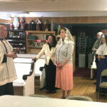 Sr. Mary Bernadette looks on while Fr. Letourneau gives a short explanation before beginning the baptism ceremony of Valerie M. at Our Lady of Mount Carmel Church in Salem, New Hampshire.
