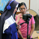 Sr. Therese Marie receives training from Mrs. Vianey Larios in lighting and filming for a series of catechism videos.