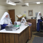 In addition to formation classes and farm work at the Novitiate, the novices help at Mary Immaculate Queen Center in the bindery and order filling rooms. Sister novices working in the bindery.