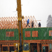 The men putting up the trusses in snow and cold rain! They had to do it that day because the crane was rented for the day at several hundred dollars an hour. (!!)
