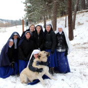 Youngsters of all ages need to play in the snow. The novitiate dog, however, rebels once again over having to be included in the picture.