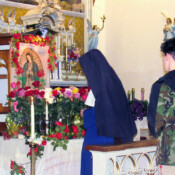 Sisters and parishioners bring roses to the shrine of Our Lady of Guadalupe during the Rosary on her feast.