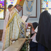 Sr. Dymphna Marie receives the blue veil and crown of roses as she makes her first profession of vows.