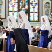 Our four new novices approach the altar, where they will receive their new names and their copies of the Holy Rule.