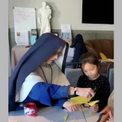 Sr. Sophia Marie helps a young student with a catechism project during a weekend mission in Boise, Idaho.