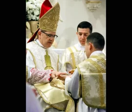 Bishop Pivarunas anoints the palms of Fr. Oliveira with the Oil of the Catechumens.