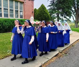The novitiate Sisters fulfilling a promise to our Lady of a yearly procession on the feast of the Queenship.