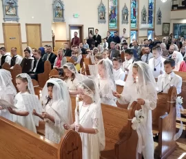 Thirteen young parishioners at Mary Immaculate Queen renew their Baptismal promises before receiving their First Holy Communion.