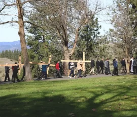 Following Jesus. Participants in the men’s Lenten retreat at Mount St. Michael take turns carrying large wooden crosses during their Rosary walk.