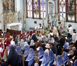 Members of the three Sodalities of Mount St. Michael bring flowers to present at Our Lady’s shrine during the parish celebration of the Queenship of the Blessed Virgin.